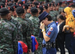 A policewoman wipes her tears