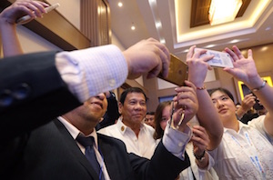 ASEAN Business & Investment Summit participants scramble to take selfies with Duterte in Laos.